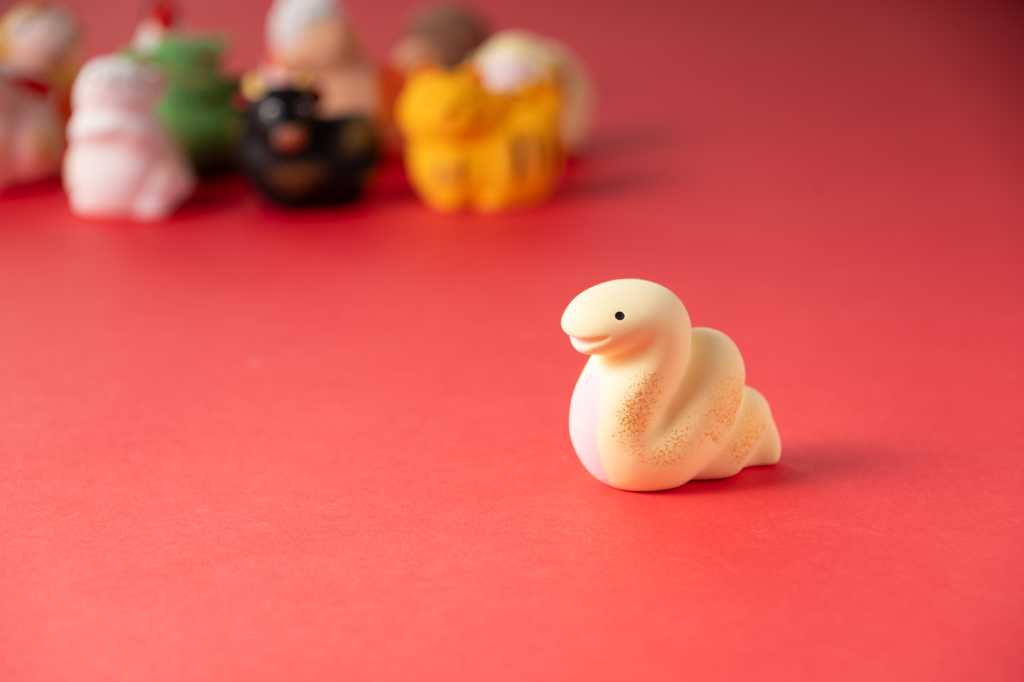 A white Python figurine slides across a light red background.